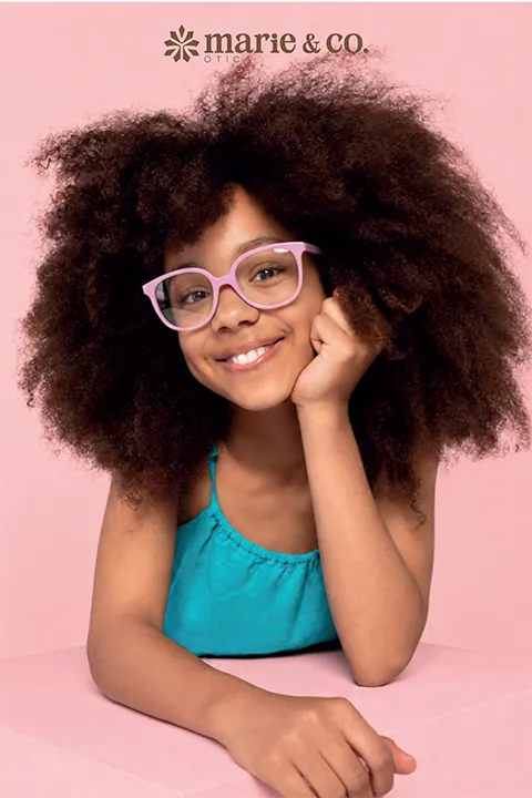 Menina sorrindo usando óculos infantil da Óticas Marié